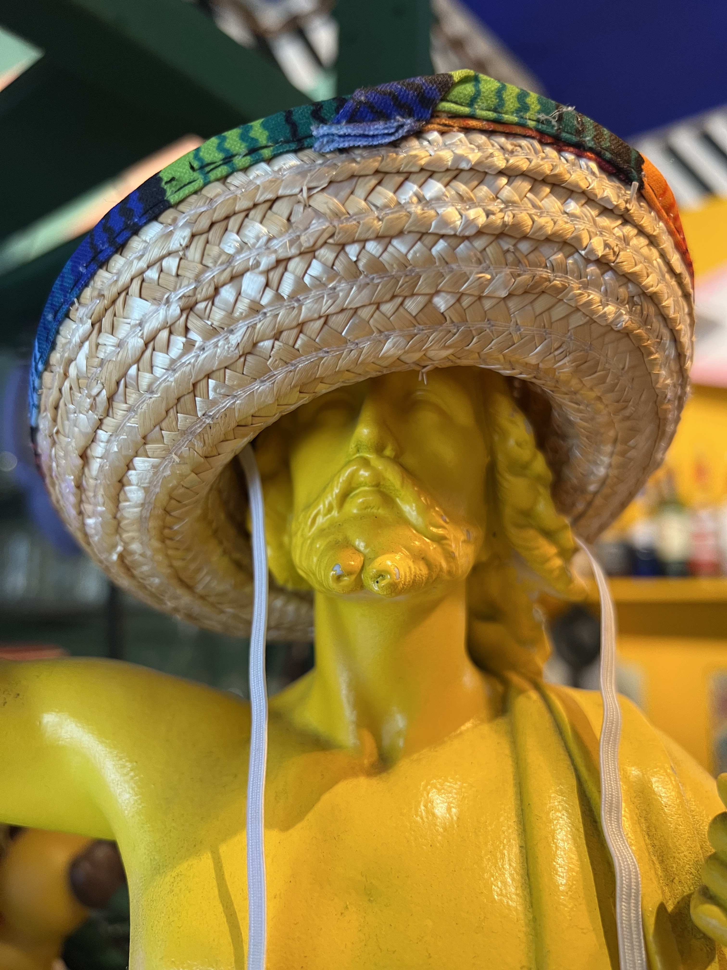 A yellow Jesus bust in a straw sombrero.