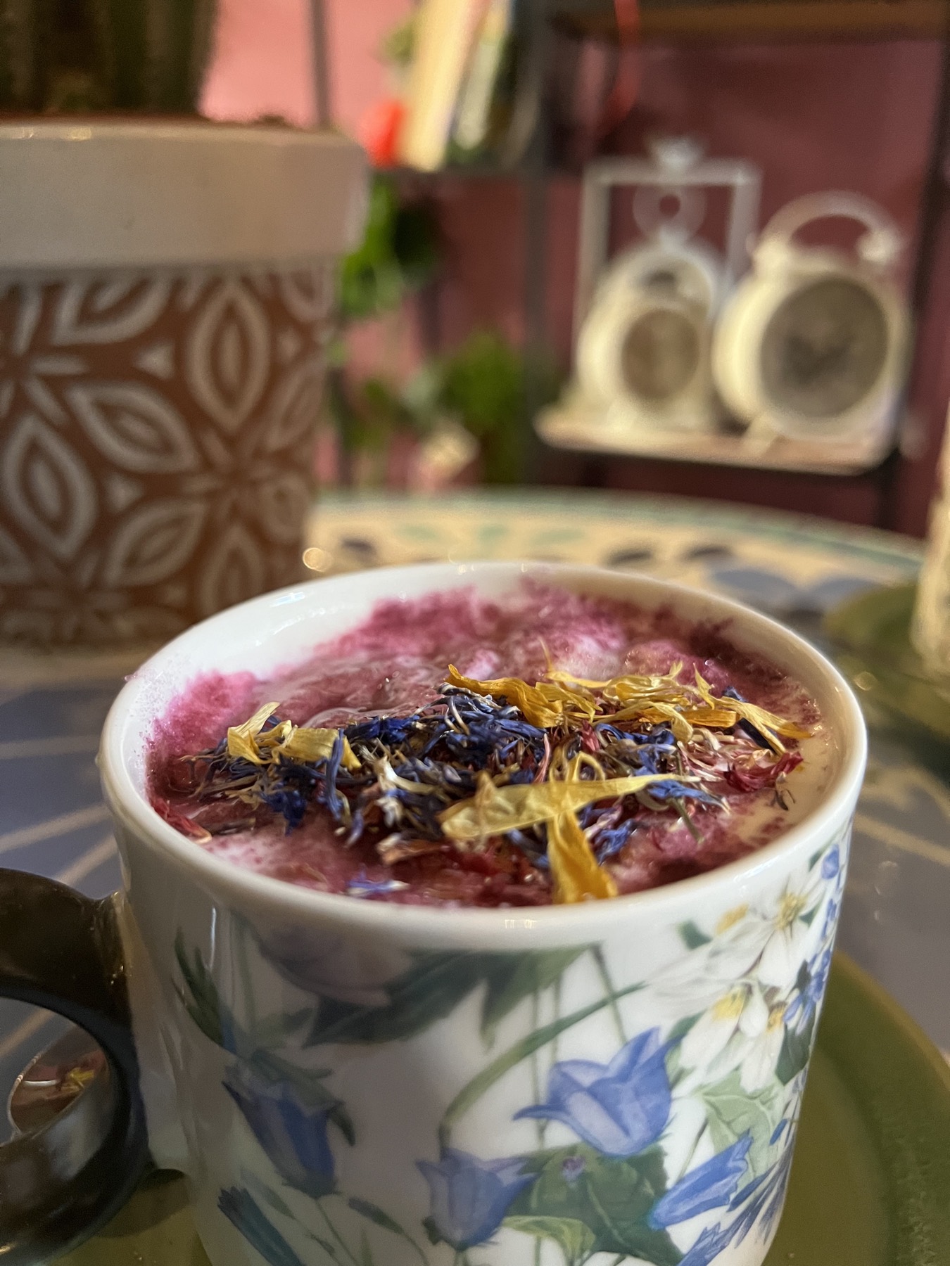 Hot chocolate with dried petals floating on top, in a flower-patterned mug